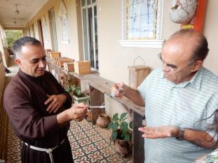 Brother Laercio (left) tasting Brother Antônio's honey.